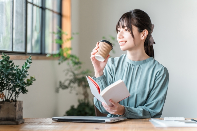 ノートに学びをメモする女性スクール生