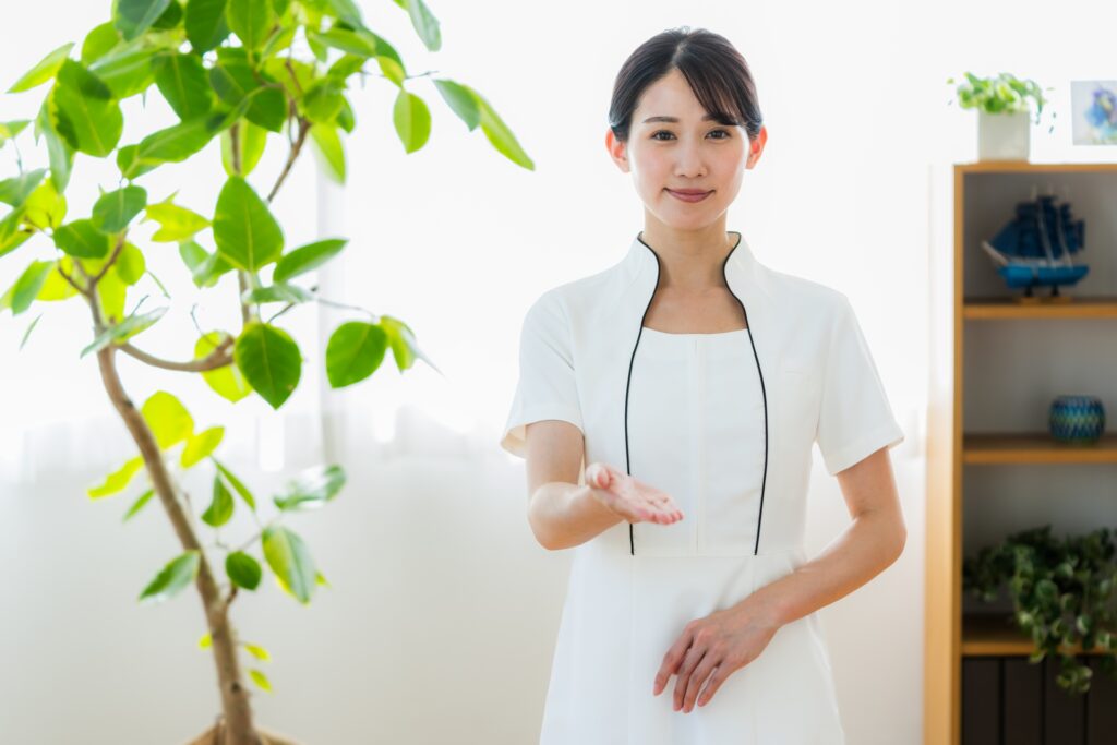 優しく微笑みながら手を差し伸べるエステティシャンの女性